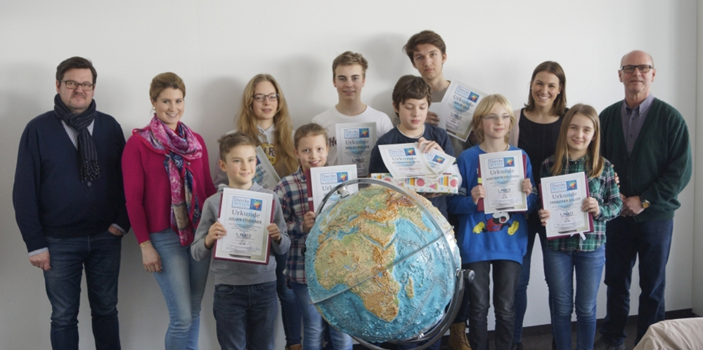 Schulleiter Christoph Müller (links) und Geo-Fachbetreuer Johannes Räpple (rechts) gratulierten den Klassensiegern der Fünften und den Schulsiegern beim diesjährigen Geo-Wettbewerb.