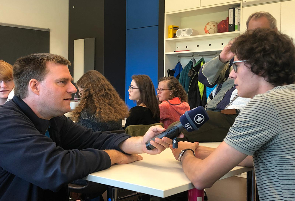 BR-Reporter Andreas Mack (links) befragte einige Q12-Schüler bezüglich ihrer Einschätzung der Wahlergebnisse vom Sonntag, hier mit Schüler Leonhard Stötter.